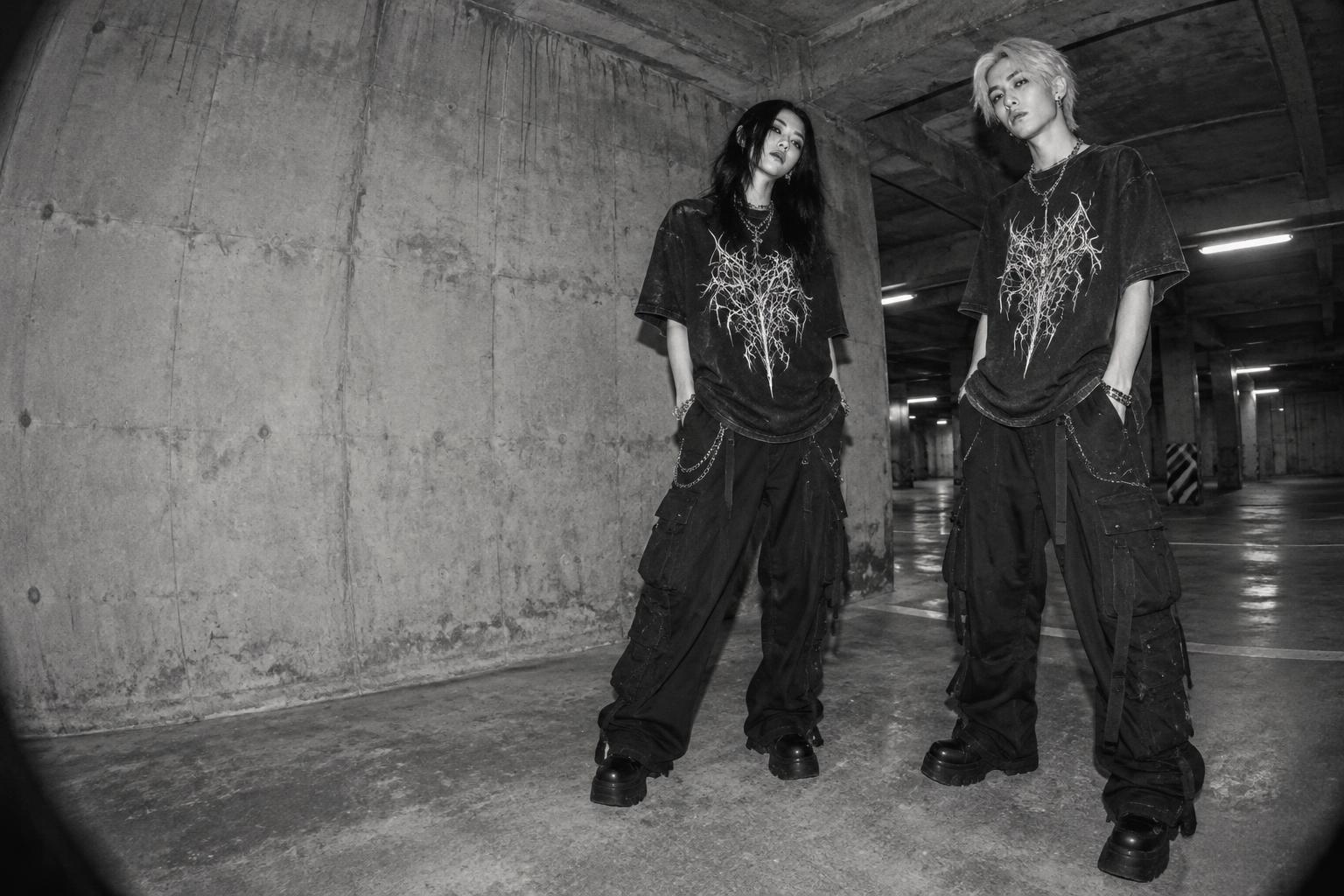Two models wearing Pantrix sigil tees and black cargo trousers in an industrial garage